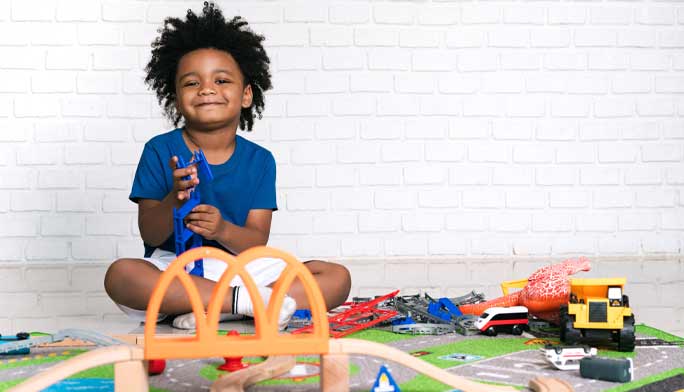 Young boy playing with toy train set