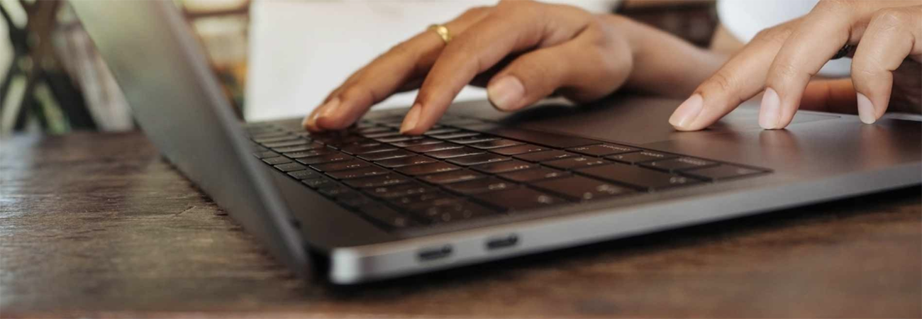 Hands typing on laptop computer keyboard