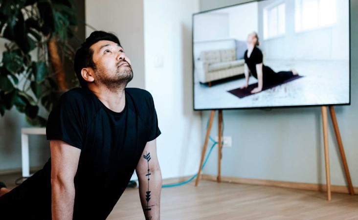 Man practicing yoga pose in living room