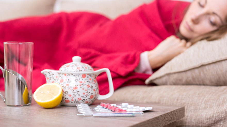 Woman lying on couch with tea and lemon on coffee table What-you-need-to-know-about-the-flu-HN1224-iStock-856979212-Sized