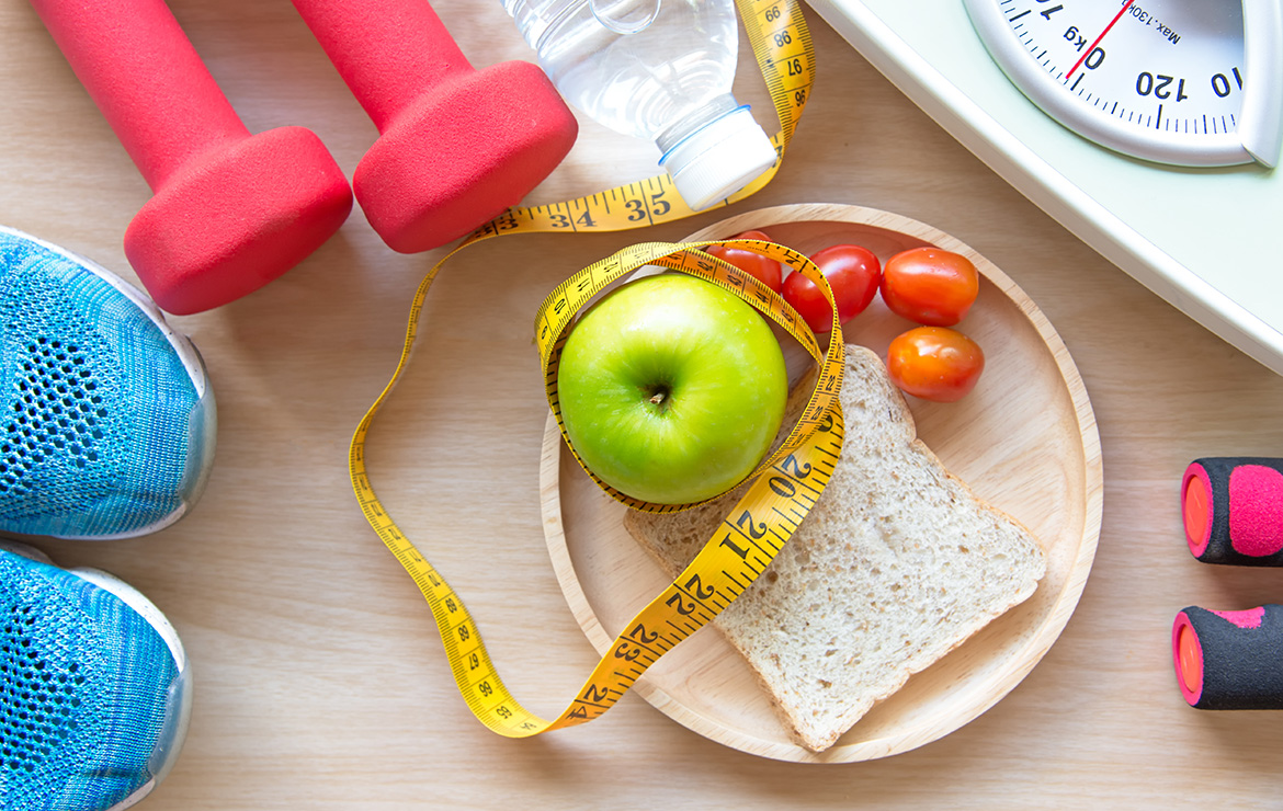 Assortment of fruits, vegetables, and bread with measuring tape