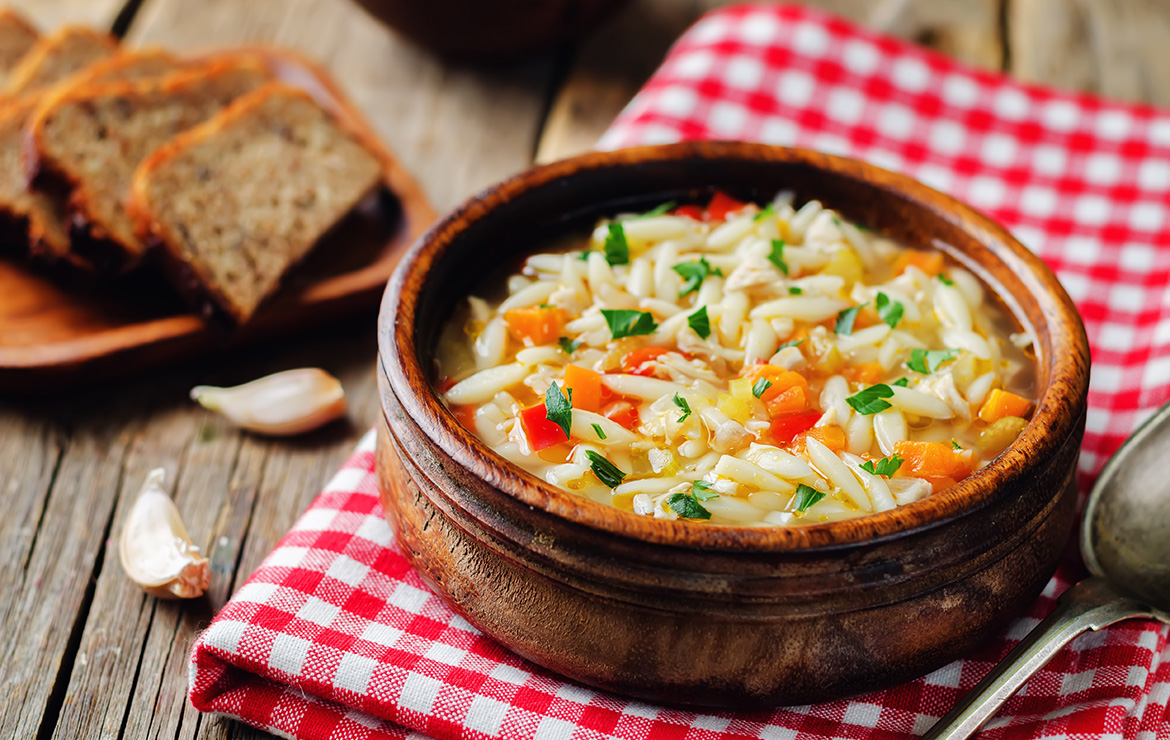 Bowl of orzo and chickpea soup on table