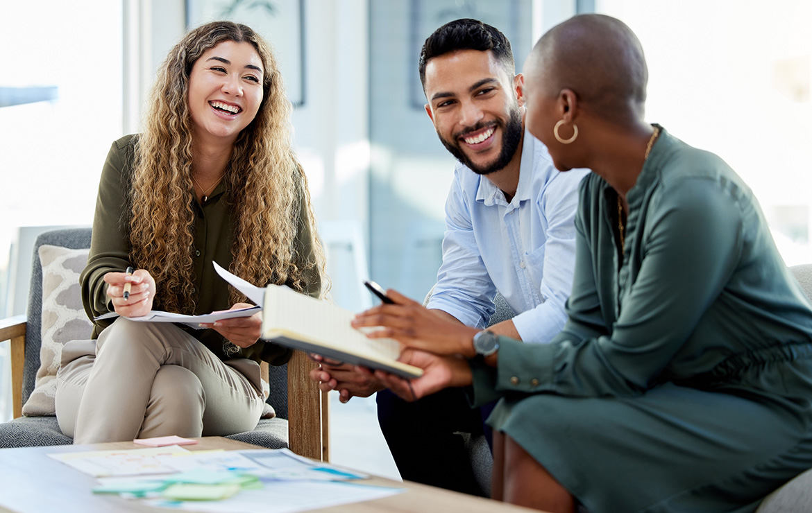 business co-workers sitting down smiling at each other