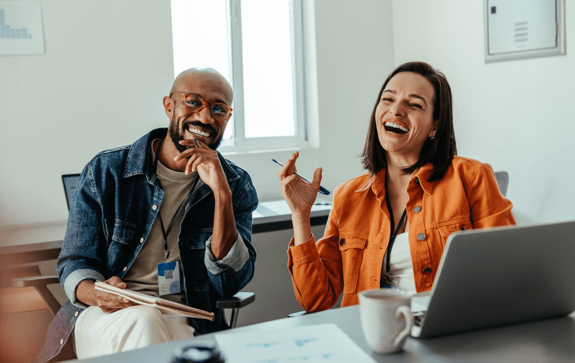 Two colleagues laughing together during meeting