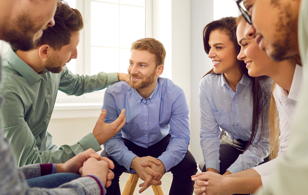 Group of colleagues sitting together encouraging team member