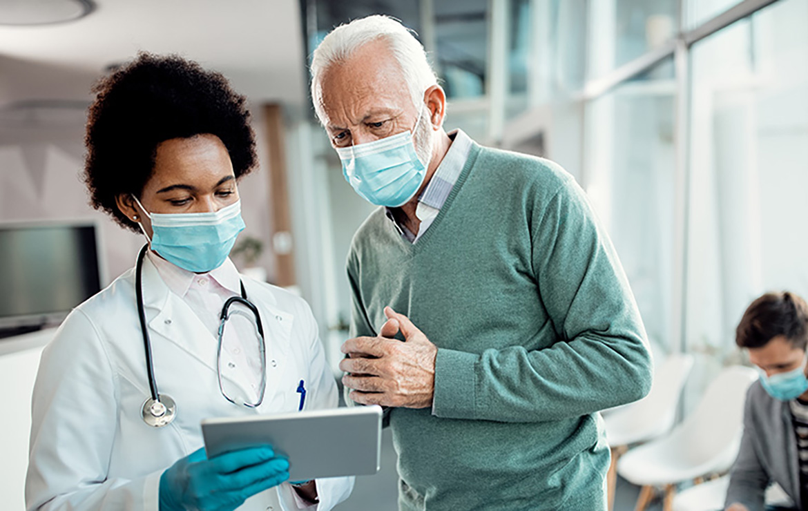 Doctor and elderly patient viewing tablet together