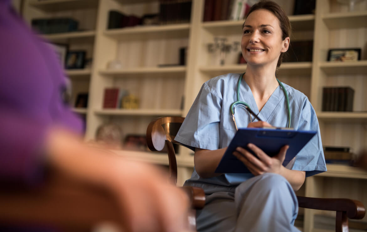 Doctor holding clipboard while listening to patient