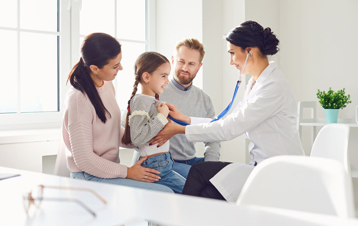 Doctor listening to heartbeat of child with parents