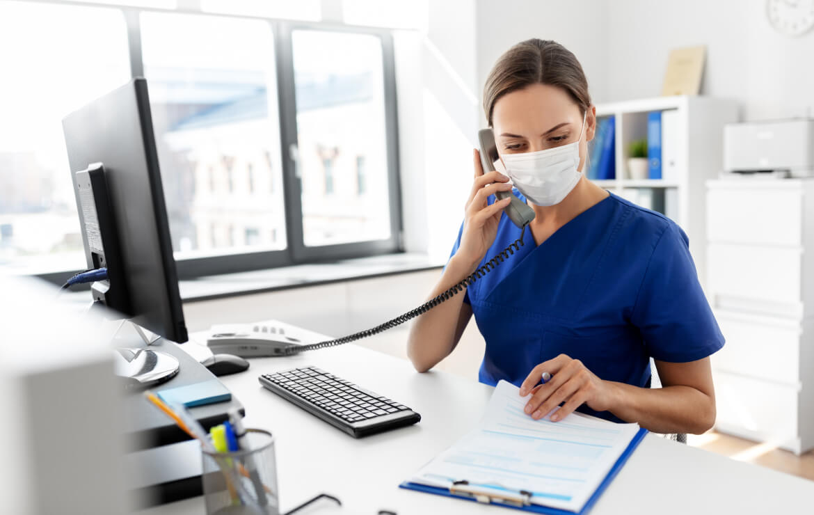 Doctor wearing face mask reviewing clipboard