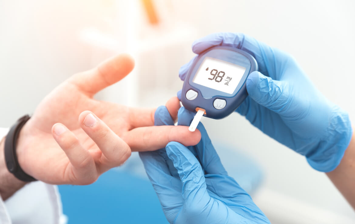 Doctor taking blood sugar level using glucometer