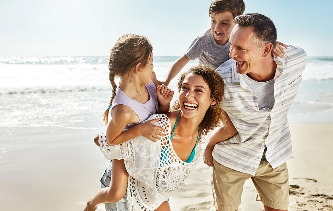 Family of four at beach smiling
