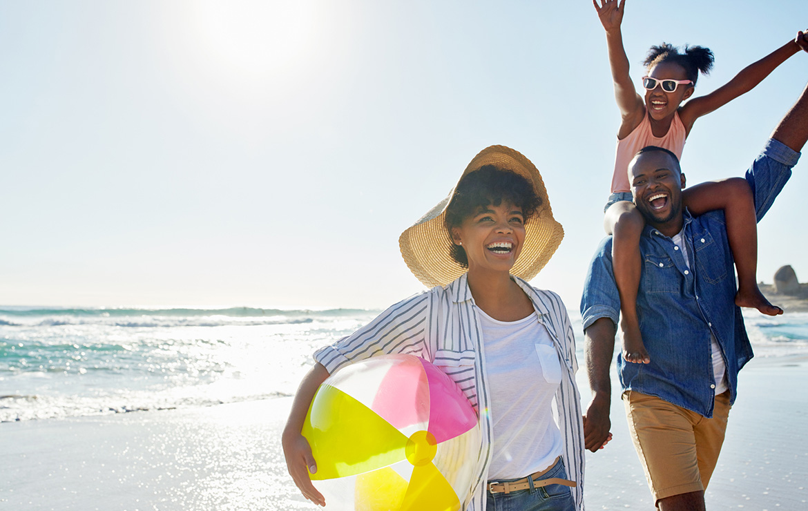 Family of three at beach smiling