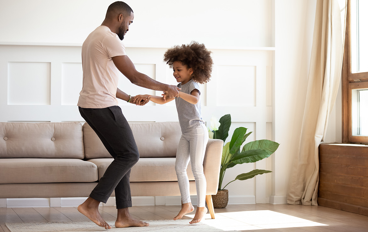 Father and daughter dancing at home