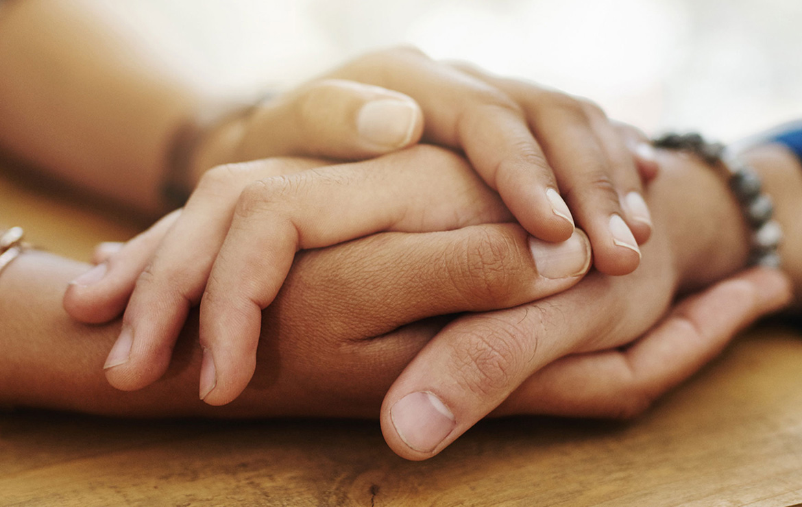 Three hands clasping each other