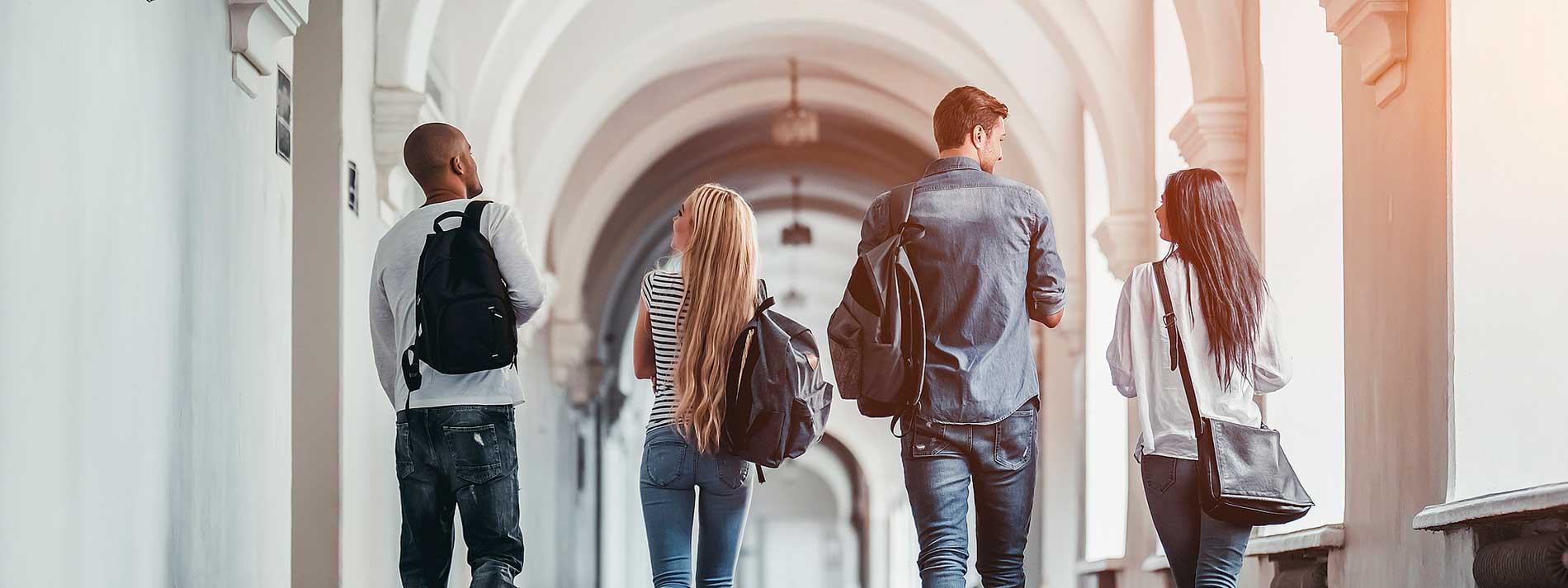 Four young adults walking down hallway