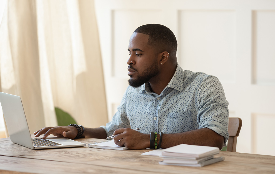 Man sitting and using laptop at desk