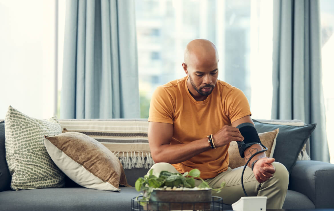 Man sitting on couch taking blood pressure