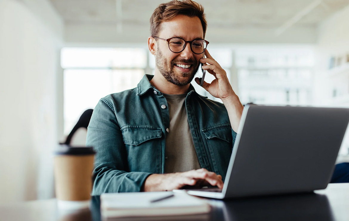 Man using phone and laptop