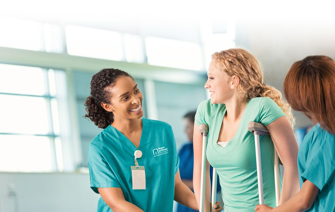 Nurse helping woman with crutches