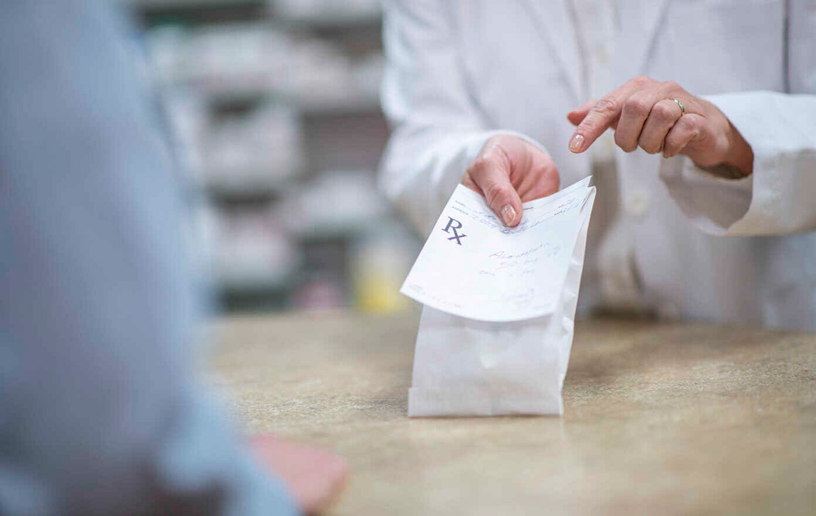 Pharmacist explaining prescription list to patient