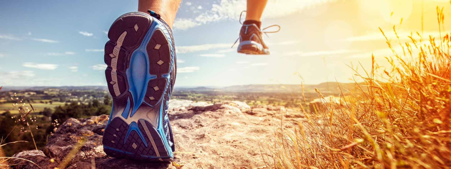 Close up of shoe running against dirt trail