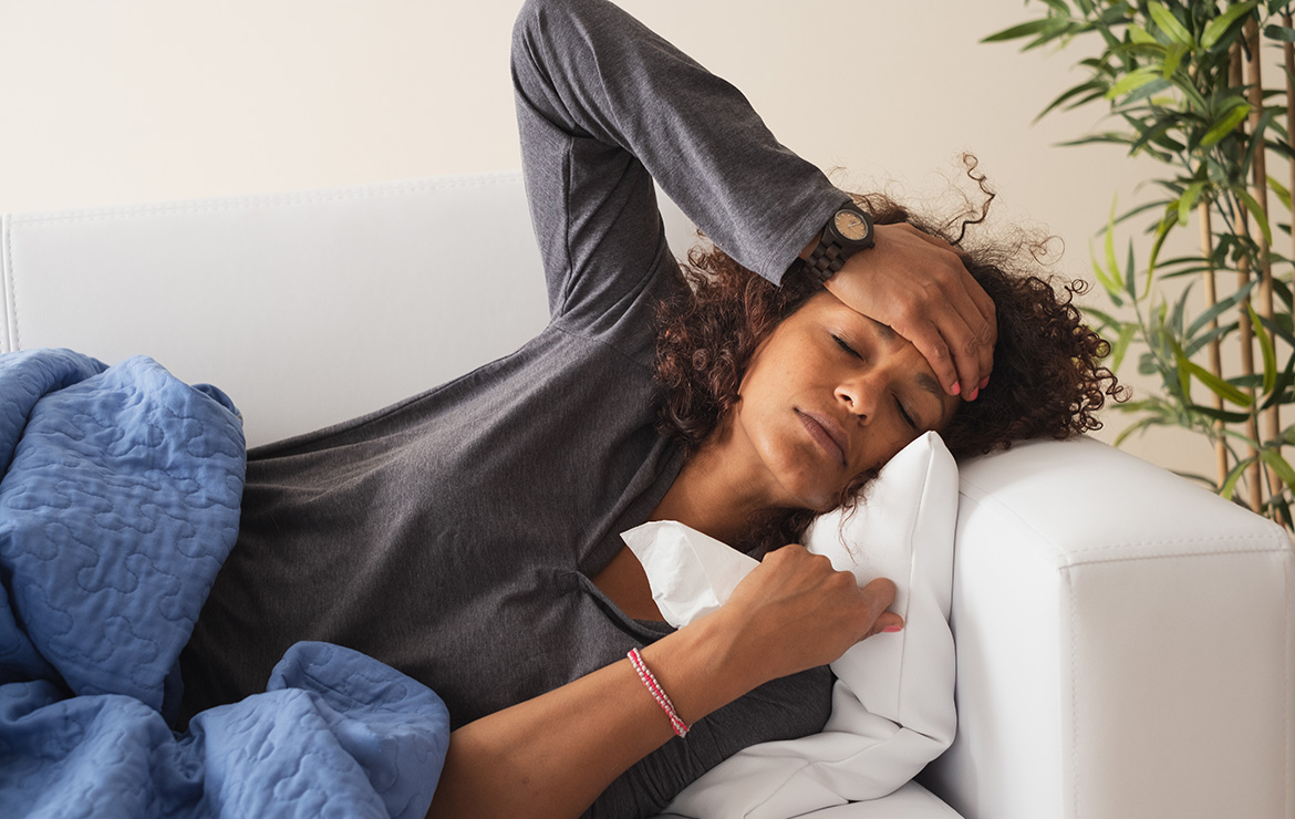 Sick woman laying down touching head