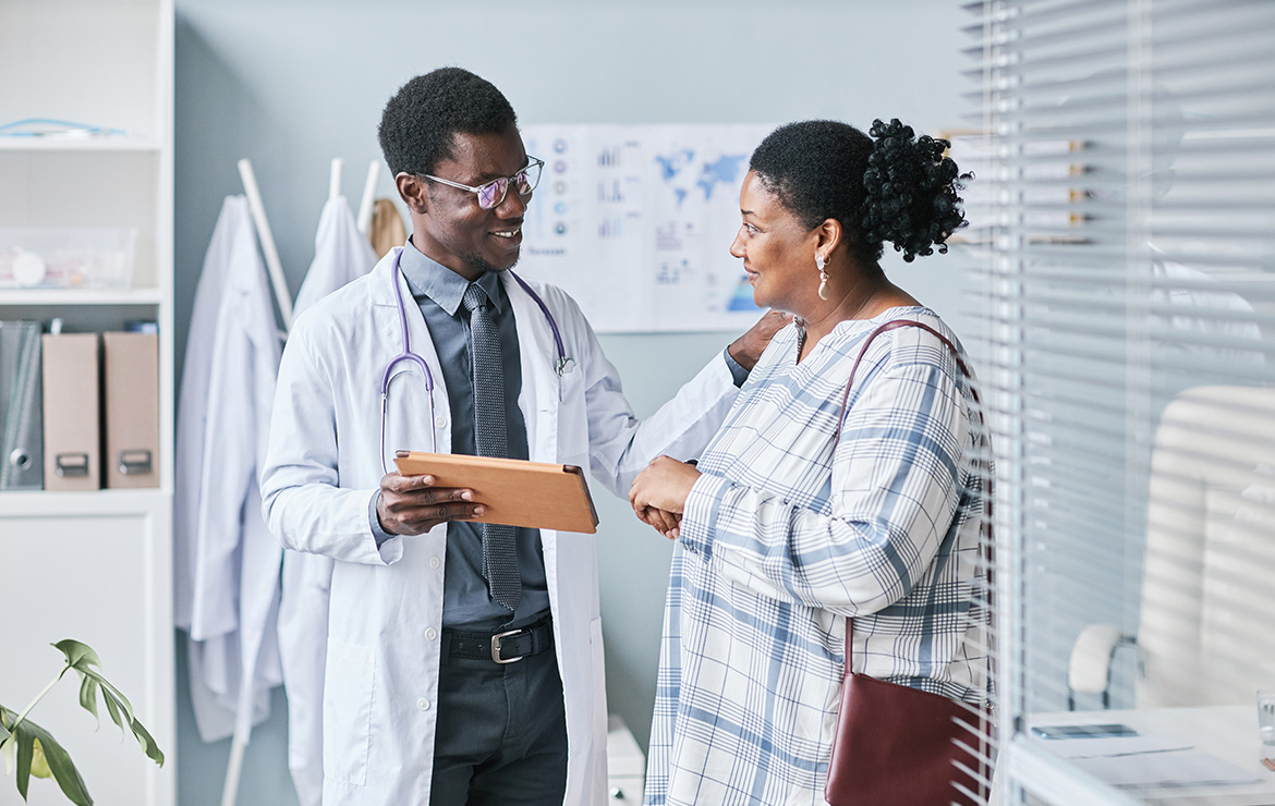 Smiling doctor shows patient a tablet