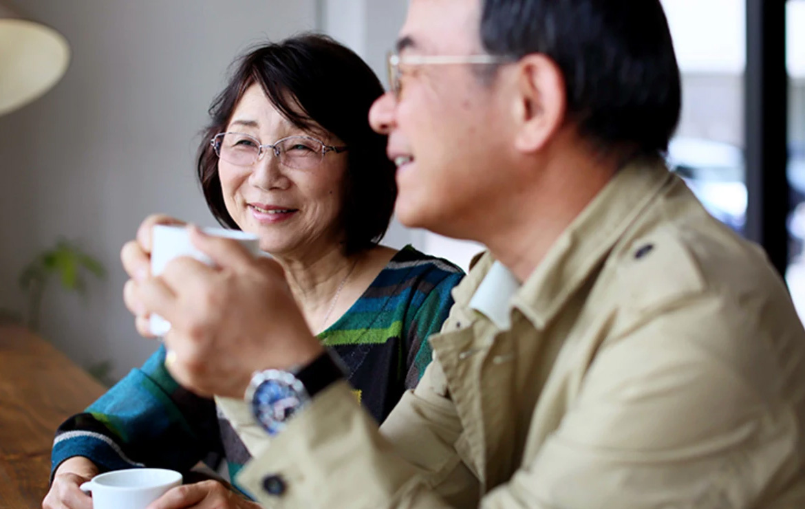 Smiling elderly couple drinking hot beverages