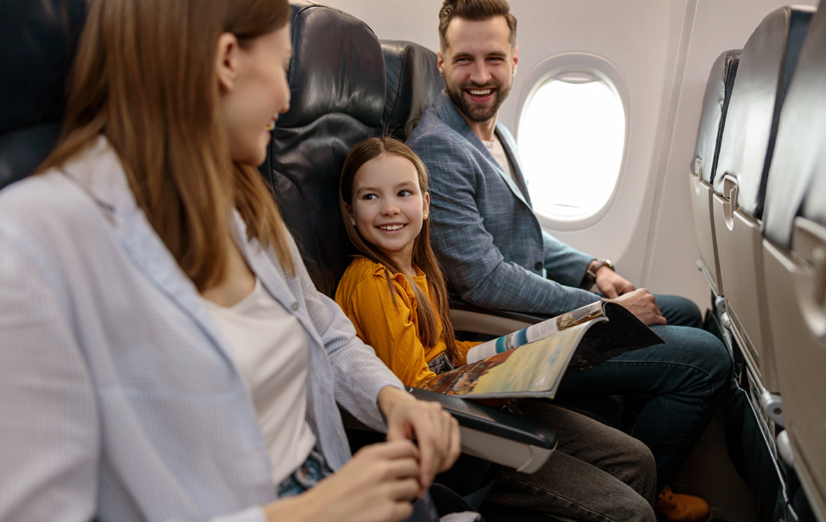 Smiling parents and child sitting inside airplane