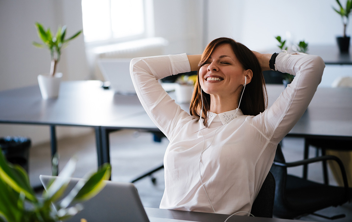 Smiling woman holding head with hands behind