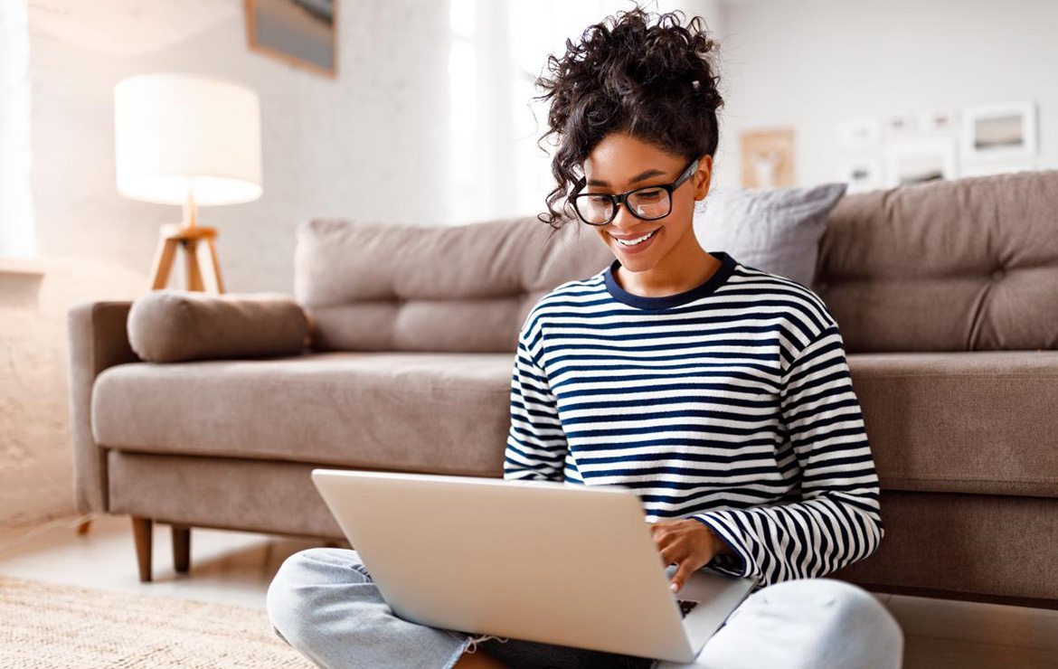 Smiling woman sitting and using laptop