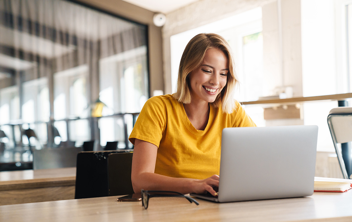 Smiling woman using laptop at the office