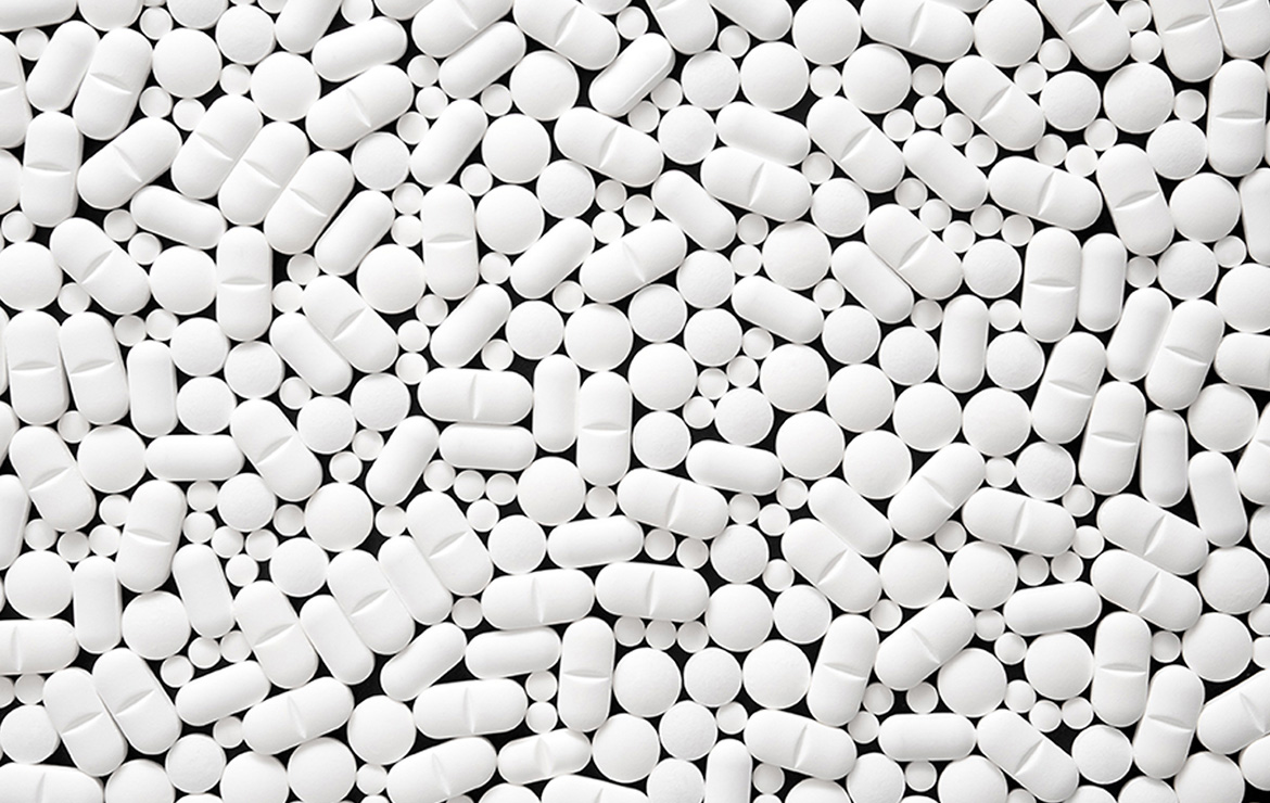 Various white-colored prescription pills scattered