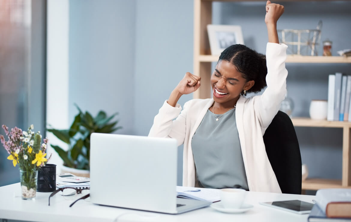 Woman celebrating at work desk
