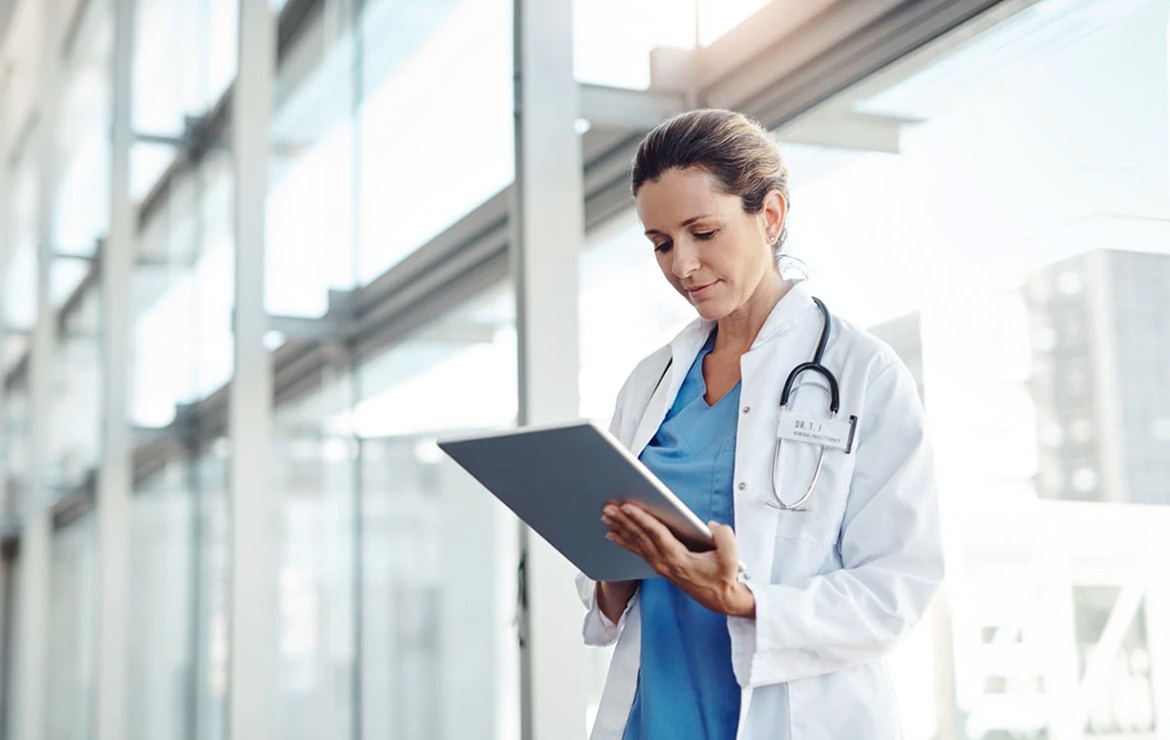 Woman doctor looking down at clipboard