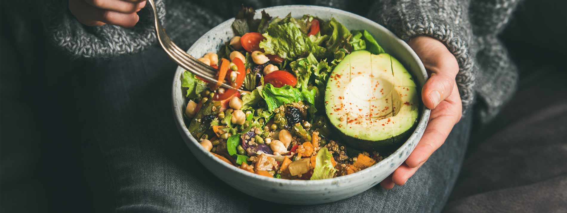 Woman eating healthy salad full of vegetables and fruit