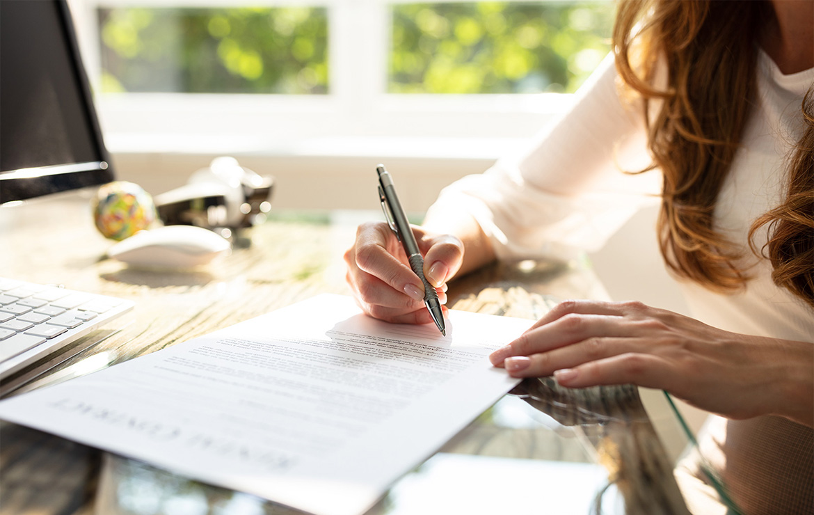 Woman filling out document with pen