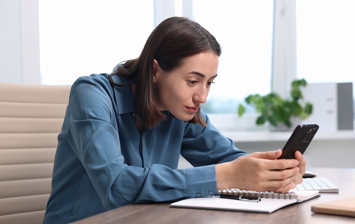 Woman hunched over using smartphone