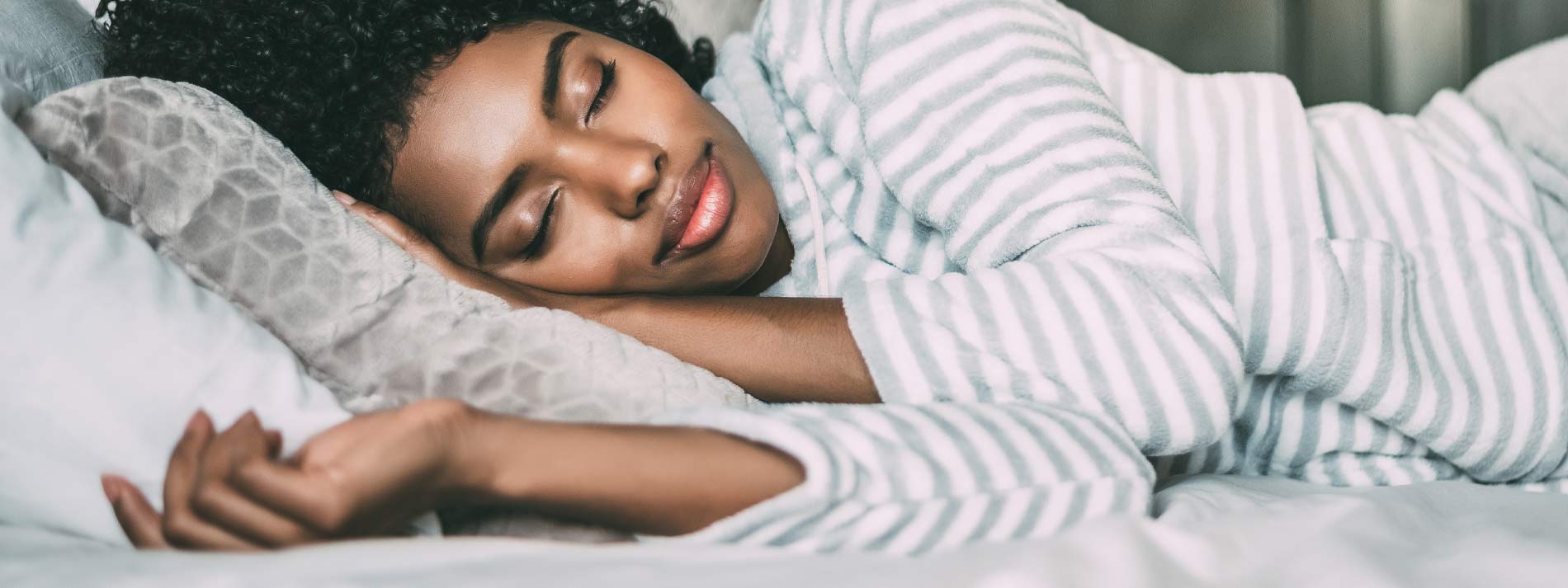 Woman sleeping in bed wearing eye mask