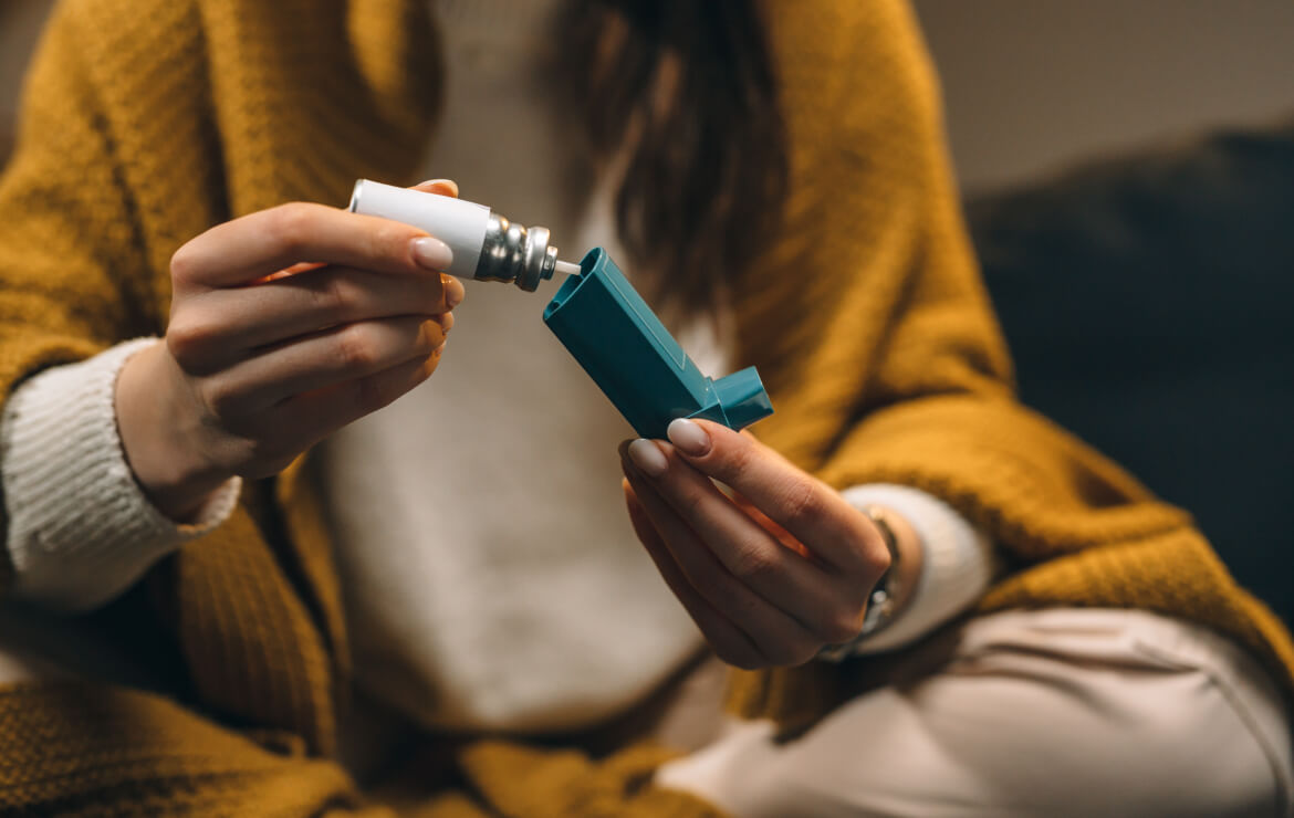 Woman sitting down and opening asthma inhaler