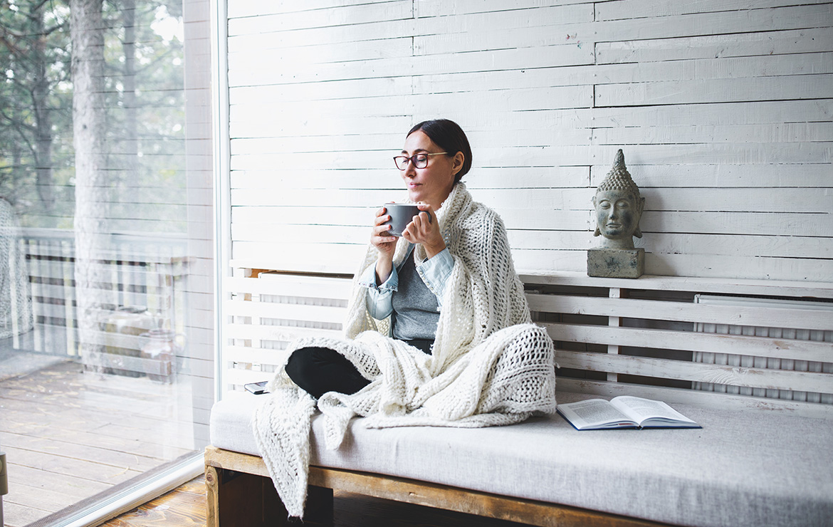 Woman sitting down holding coffee mug