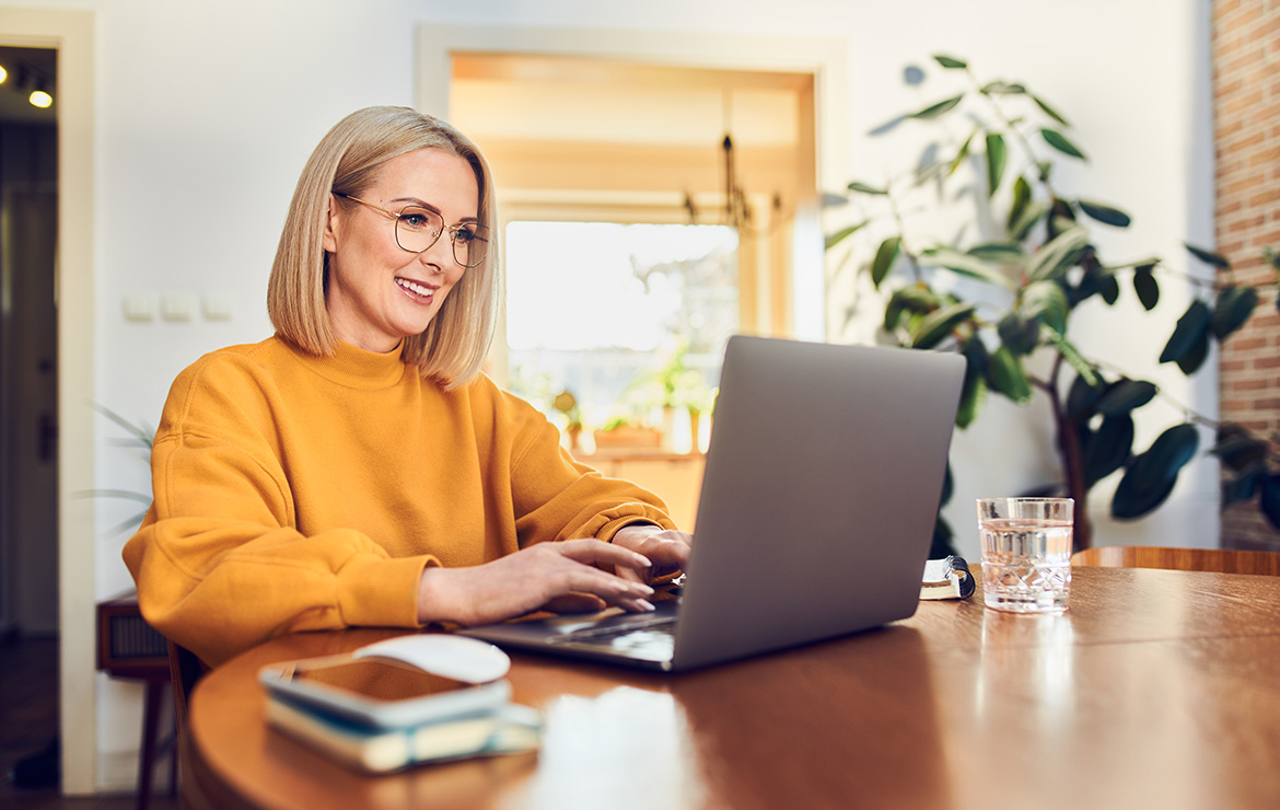 Woman sitting down using laptop at home