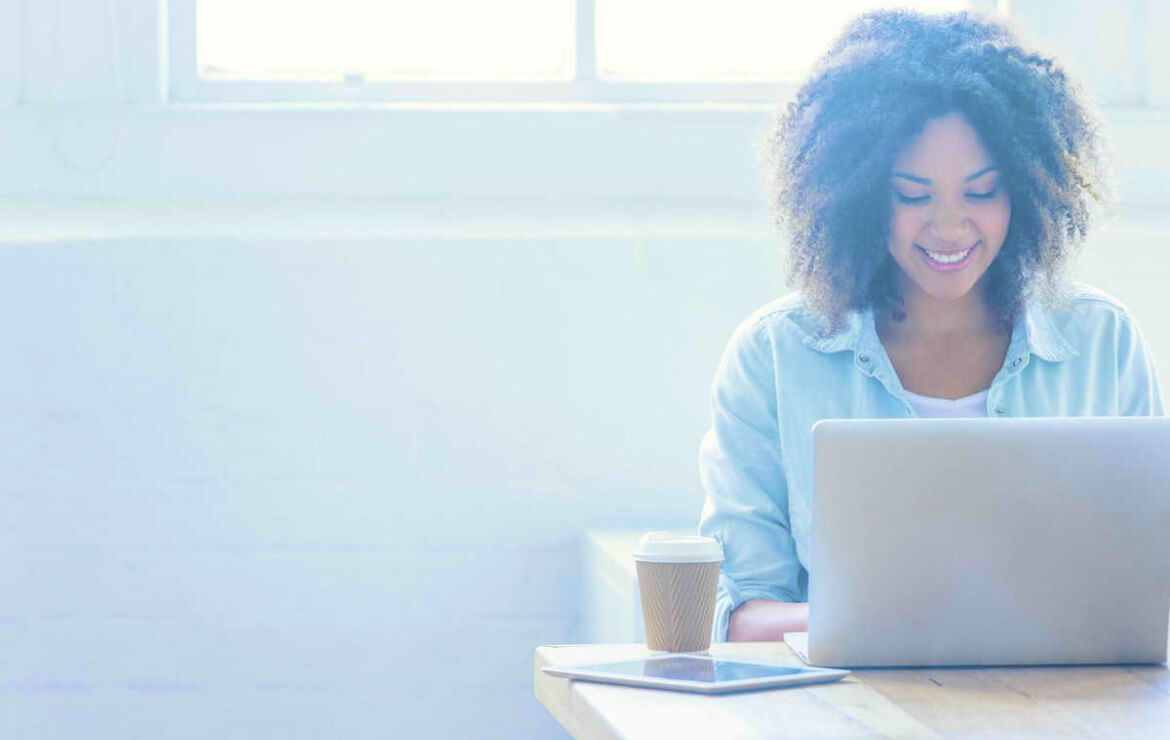 Woman using laptop while sitting in coffeeshop