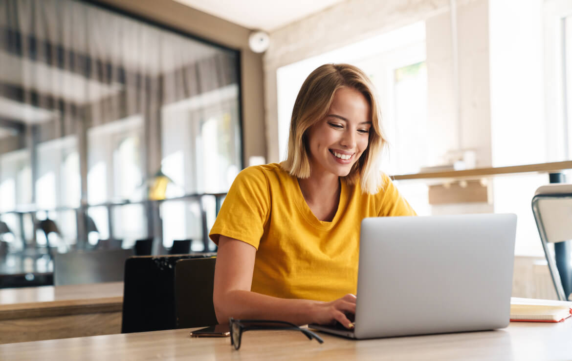 Woman sitting in office typing on laptop