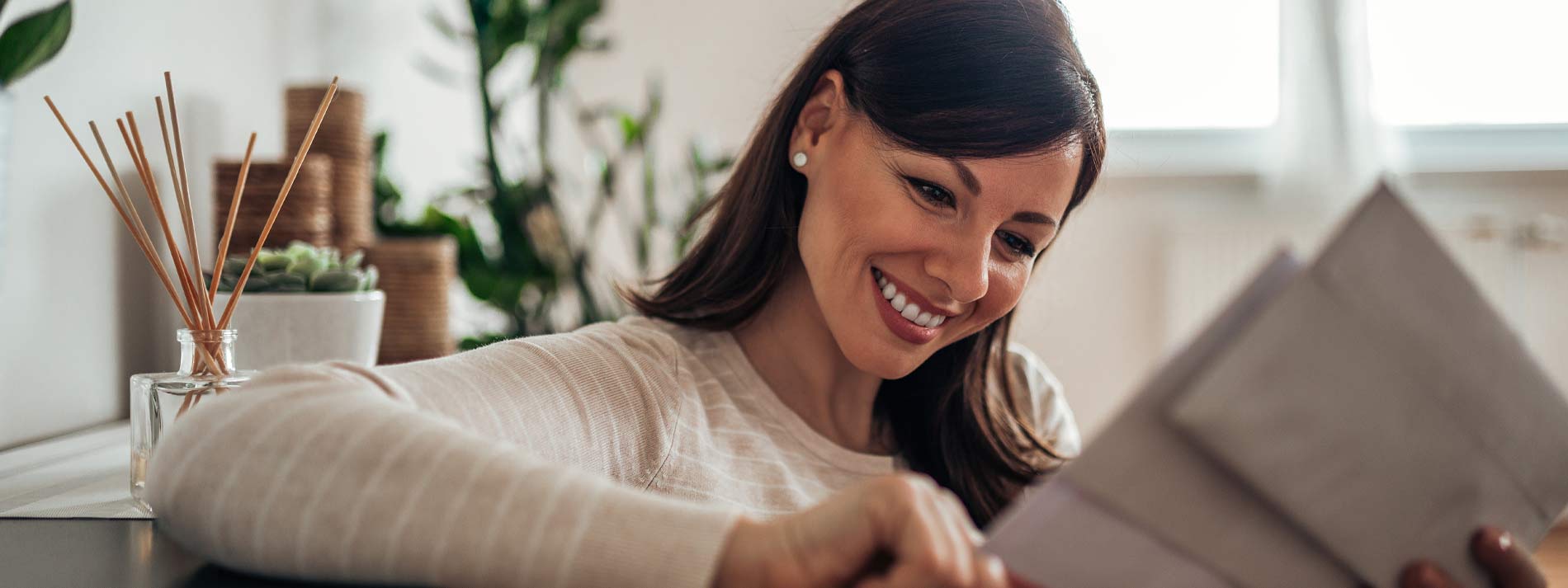 Woman-smiling-and-looking-at-mail