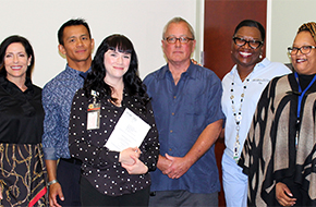 Grateful patient Kevin Cook with his smiling caregivers