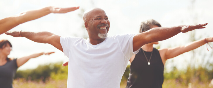 Group of men and women practicing yoga outside