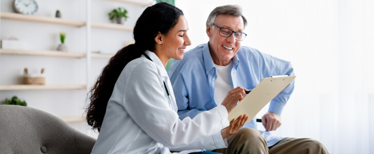 Doctor reviewing clipboard with older patient
