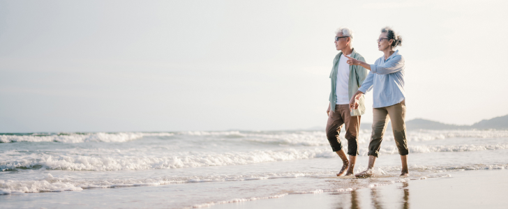 Older couple walking together on the beach