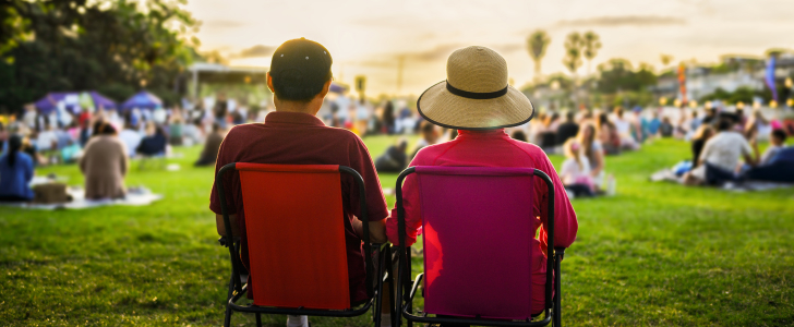 Couple sitting on picnic chairs at outdoor concert